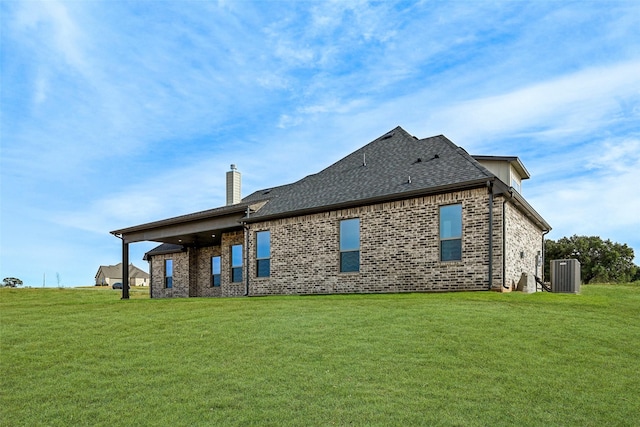 back of property featuring a yard and central air condition unit