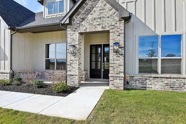 entrance to property with french doors and a yard