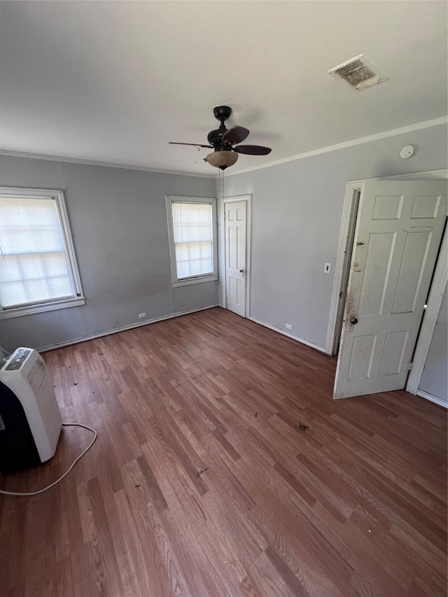 unfurnished bedroom with hardwood / wood-style floors, crown molding, and ceiling fan