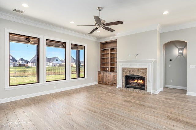 unfurnished living room featuring light hardwood / wood-style flooring, ornamental molding, and a fireplace