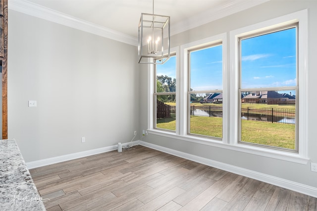 unfurnished dining area with ornamental molding, a chandelier, light hardwood / wood-style floors, and a water view