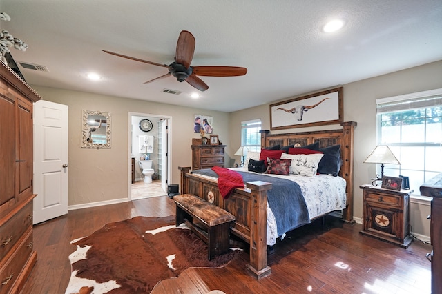 bedroom featuring dark hardwood / wood-style floors, ensuite bath, and ceiling fan