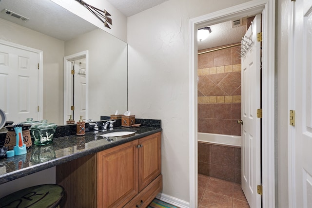 bathroom featuring tile patterned flooring, vanity, and a textured ceiling