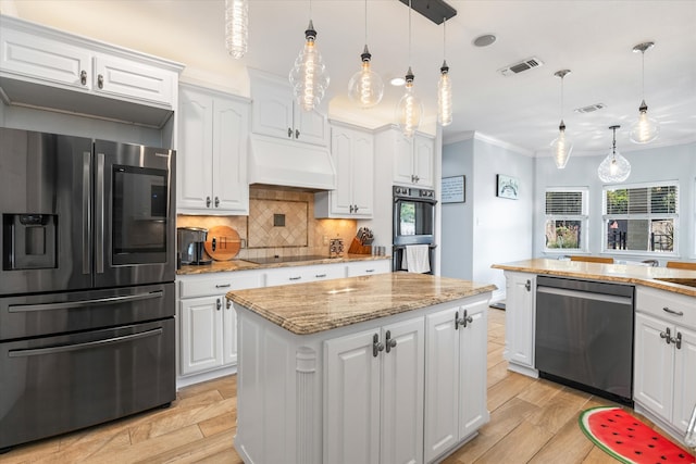 kitchen with custom exhaust hood, white cabinetry, black appliances, a center island, and backsplash