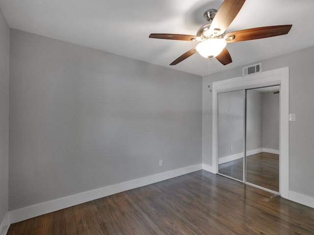 unfurnished bedroom with ceiling fan, dark hardwood / wood-style flooring, and a closet