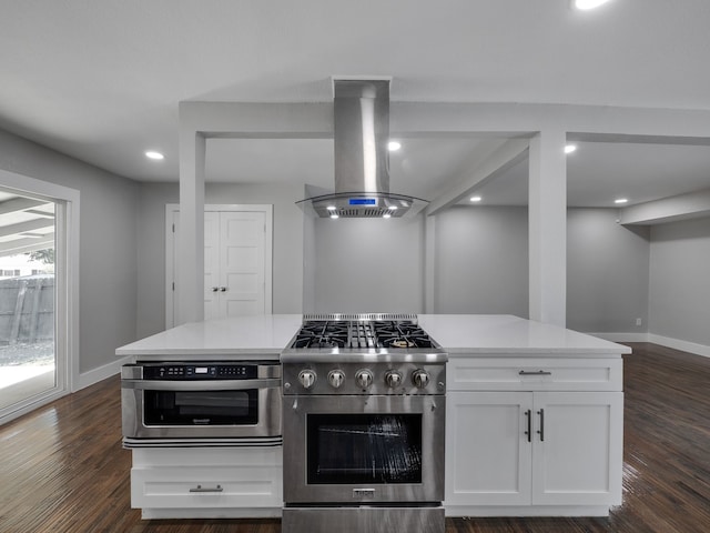 kitchen with island exhaust hood, appliances with stainless steel finishes, dark hardwood / wood-style floors, and white cabinets