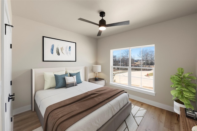 bedroom with ceiling fan and light hardwood / wood-style flooring