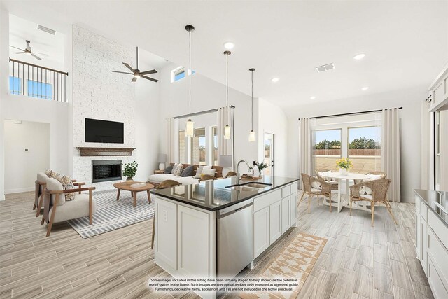 kitchen featuring hanging light fixtures, dishwasher, sink, and white cabinets