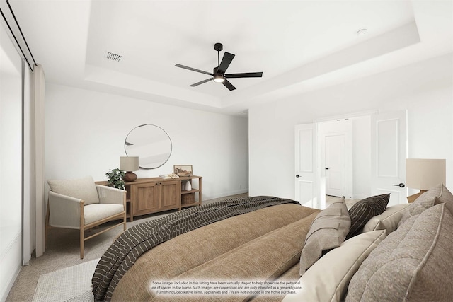 interior space with a tray ceiling, ceiling fan, and carpet flooring