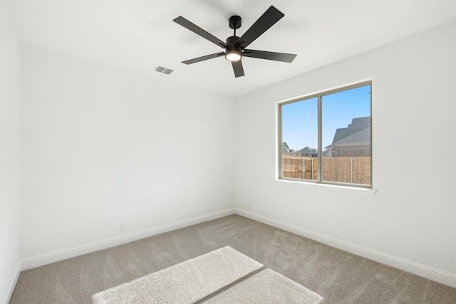 spare room with ceiling fan and light carpet