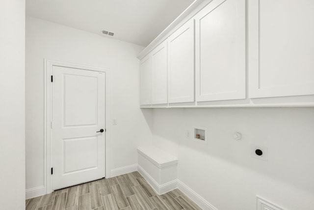 laundry room featuring gas dryer hookup, cabinets, washer hookup, and electric dryer hookup