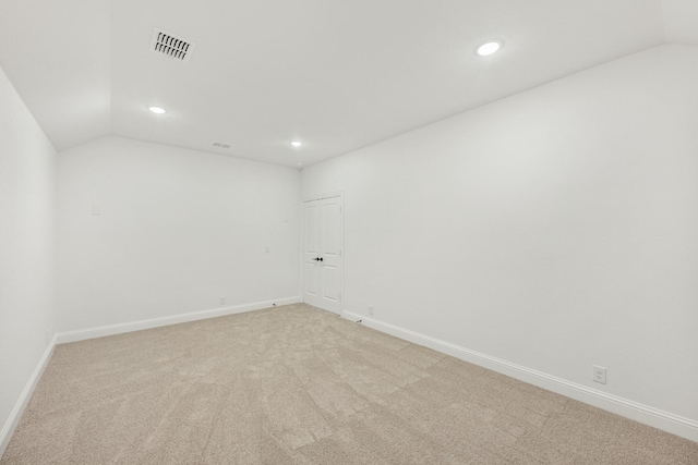 carpeted spare room with lofted ceiling