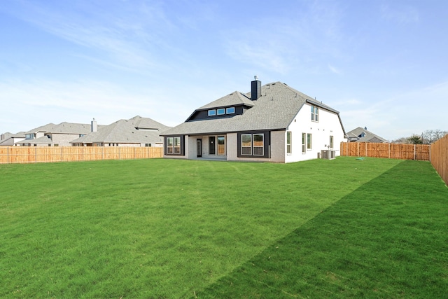 back of house featuring central air condition unit and a lawn