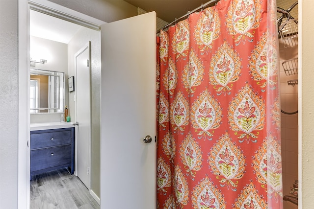 bathroom with hardwood / wood-style floors, a shower with curtain, and vanity