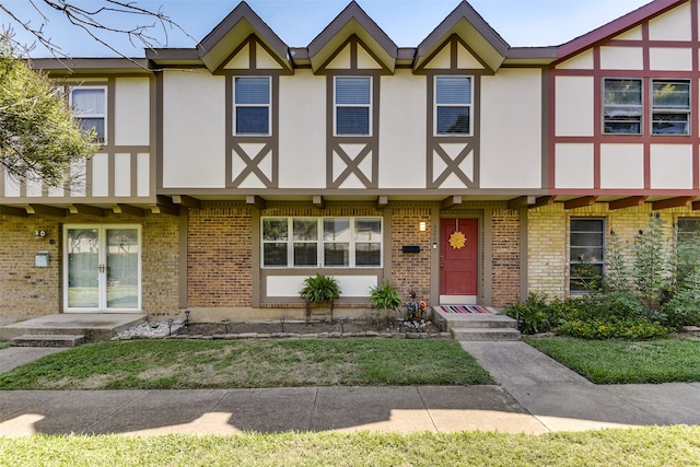 townhome / multi-family property featuring stucco siding and brick siding