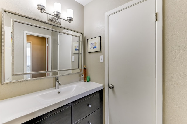 bathroom featuring vanity and a textured wall