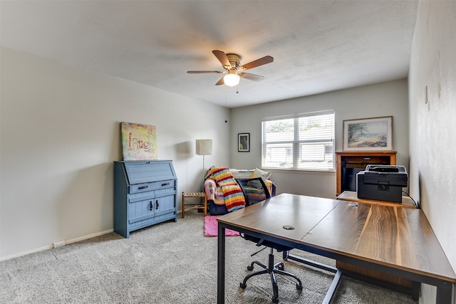 office area featuring a ceiling fan, light colored carpet, and baseboards