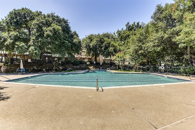 community pool featuring a patio and fence