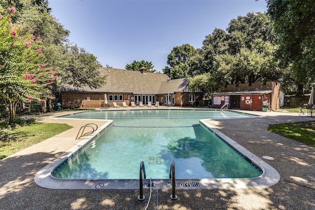 view of pool featuring an outbuilding and a patio area