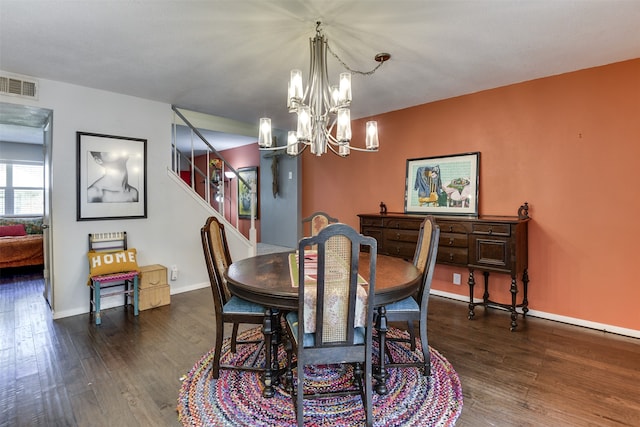 dining space with baseboards, visible vents, an inviting chandelier, and wood finished floors