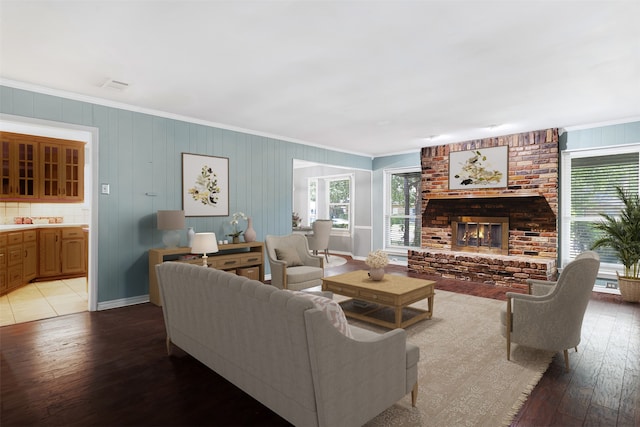 living room featuring a brick fireplace, hardwood / wood-style flooring, and crown molding