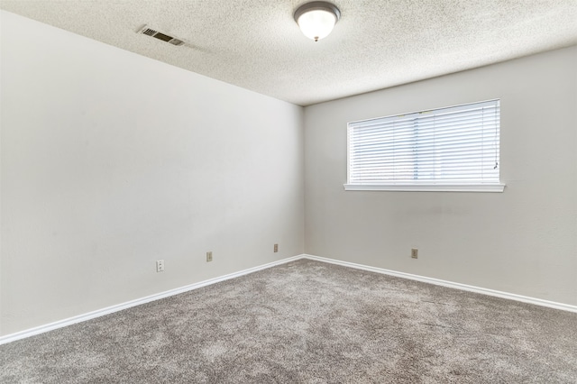 unfurnished room with a textured ceiling and carpet floors