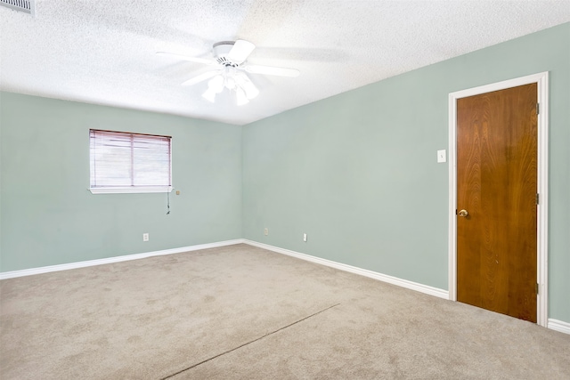 spare room featuring ceiling fan, carpet floors, and a textured ceiling