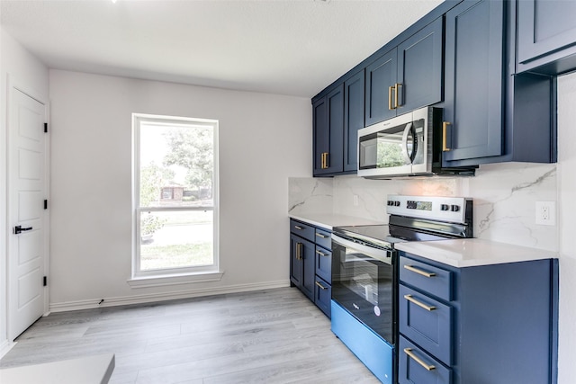 kitchen featuring a wealth of natural light, appliances with stainless steel finishes, and blue cabinetry