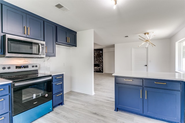 kitchen featuring light hardwood / wood-style floors, a premium fireplace, stainless steel appliances, blue cabinets, and a chandelier