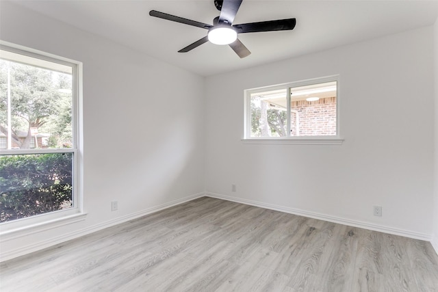 empty room with ceiling fan and light hardwood / wood-style flooring