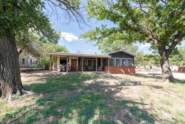 1001 Miller Shores Rd Unit 1, Henrietta, TX 76365 - back of house with a sunroom, brick siding, metal roof, and a patio