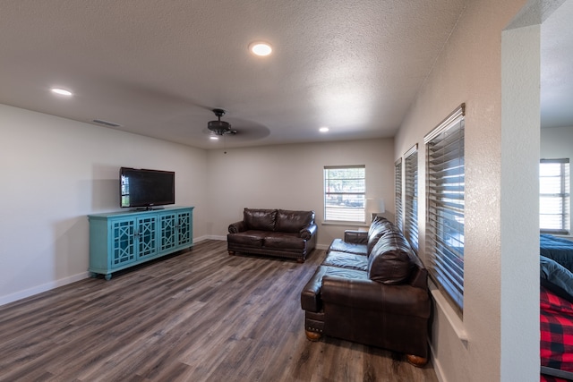 living room featuring a textured ceiling, dark hardwood / wood-style floors, and ceiling fan