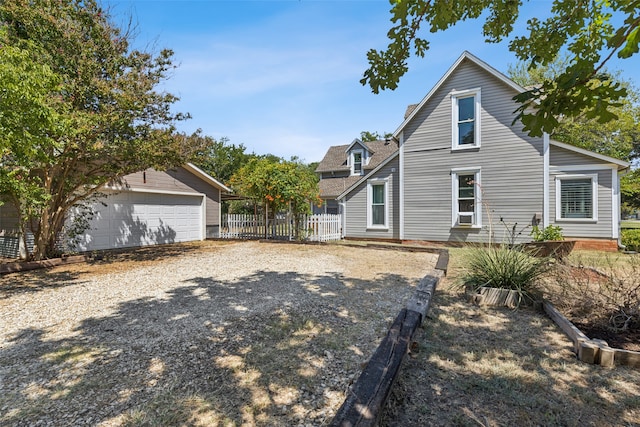 back of house with a garage and an outdoor structure