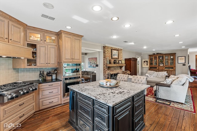 kitchen with backsplash, stainless steel appliances, dark hardwood / wood-style flooring, and a center island