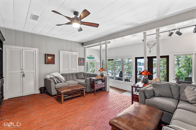 living room featuring ceiling fan and a healthy amount of sunlight