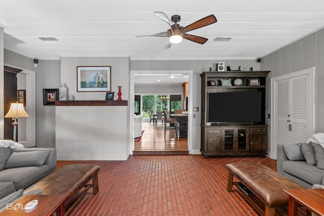 living room with brick floor, ceiling fan, and visible vents