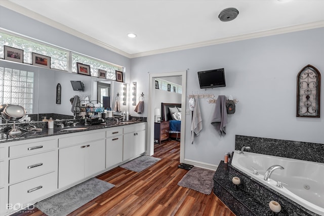 bathroom with a bathing tub, double vanity, ornamental molding, and hardwood / wood-style floors