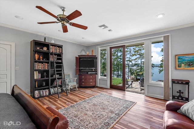 living room with ceiling fan, crown molding, and wood-type flooring