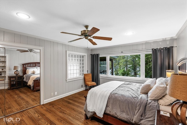 bedroom with baseboards, wood finished floors, a ceiling fan, and crown molding