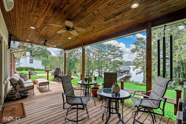 wooden terrace featuring ceiling fan and a yard