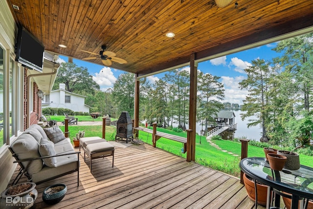 wooden deck featuring a ceiling fan, a water view, a yard, and outdoor lounge area