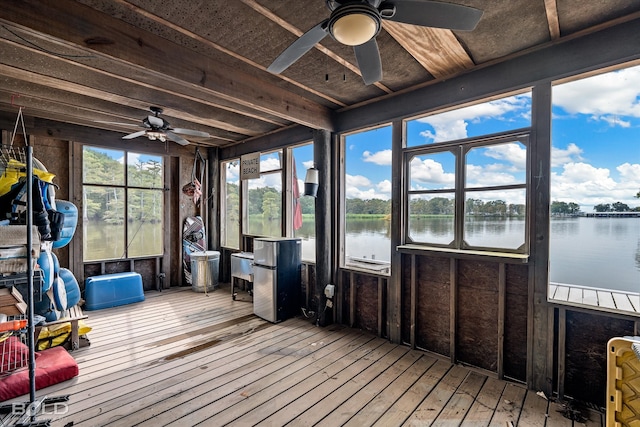 sunroom featuring radiator heating unit, ceiling fan, and a water view