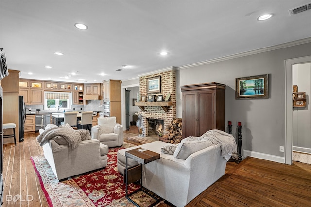 living room with a fireplace, brick wall, hardwood / wood-style flooring, and crown molding