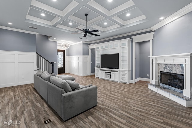 living room featuring a high end fireplace, coffered ceiling, ornamental molding, ceiling fan, and dark hardwood / wood-style floors