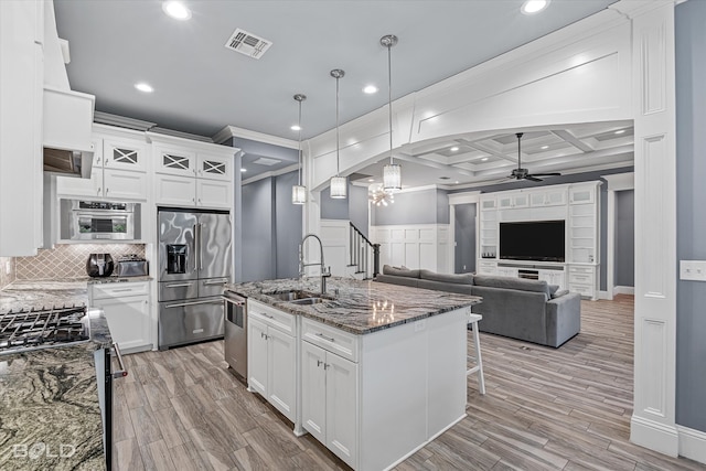 kitchen featuring coffered ceiling, appliances with stainless steel finishes, ceiling fan, light hardwood / wood-style floors, and beamed ceiling