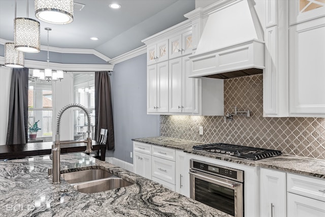 kitchen with stainless steel appliances, backsplash, premium range hood, stone counters, and white cabinets