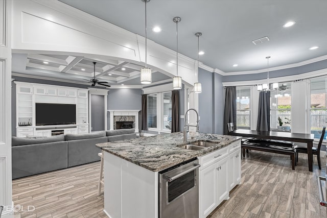 kitchen featuring light hardwood / wood-style flooring, white cabinets, a fireplace, coffered ceiling, and sink