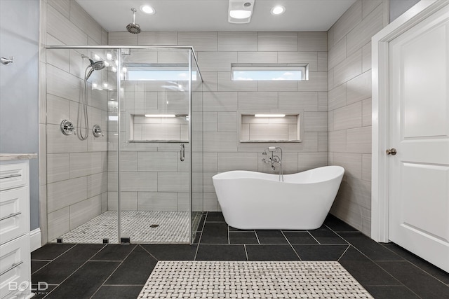 bathroom featuring an enclosed shower, tile walls, and tile patterned flooring