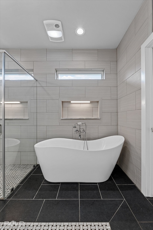 bathroom featuring tile patterned floors, tile walls, and walk in shower