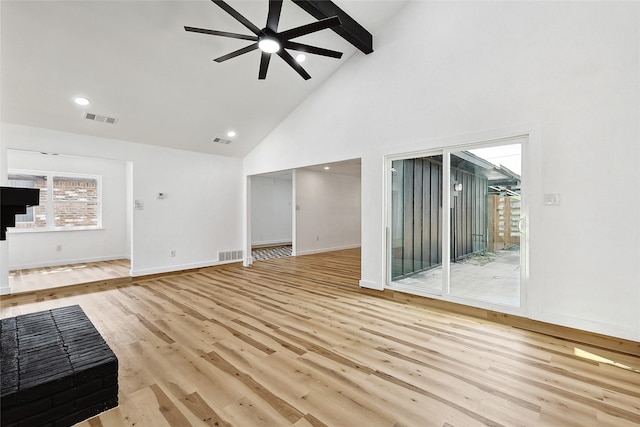 unfurnished living room with ceiling fan, beam ceiling, high vaulted ceiling, and light hardwood / wood-style flooring